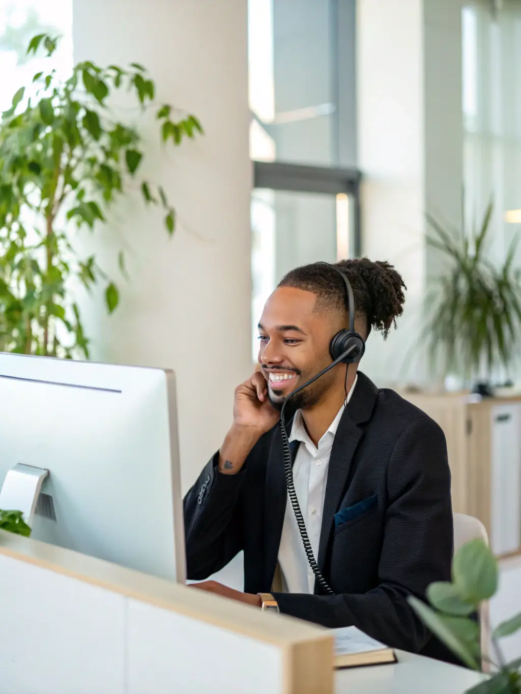 A customer service representative smiling while interacting with a customer, with an AI voice agent assisting in the background.